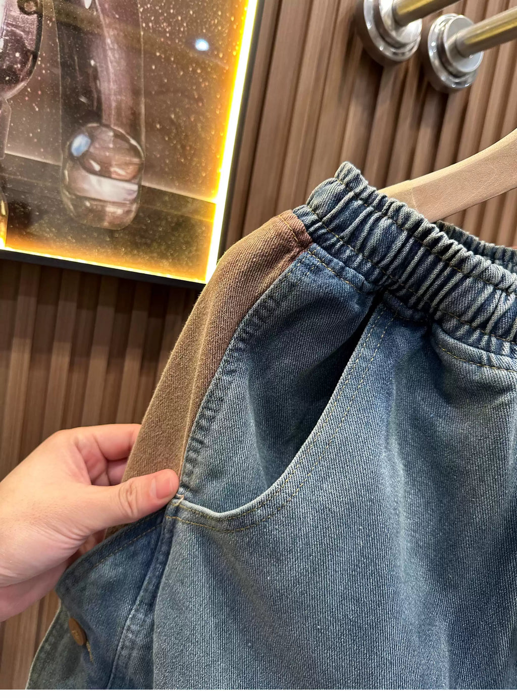 Close-up view of the Common Theory Vintage Panel Denim Shorts in vintage blue, highlighting the contrast brown corduroy side paneling, elastic waistband, and side-entry front pocket.